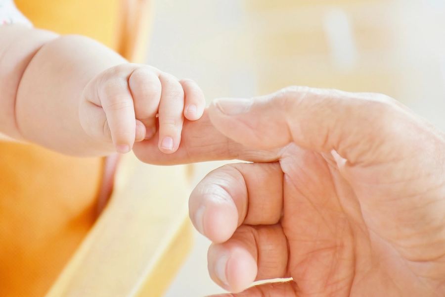 Babyhand hält einen Finger
